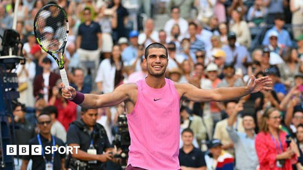 Carlos Alcaraz holding his arms wide in celebration
