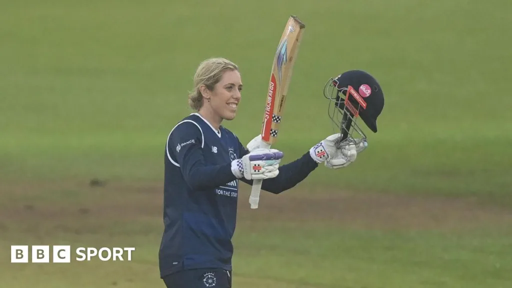 Georgia Adams raises her bat to acknowledge her century for Hampshire